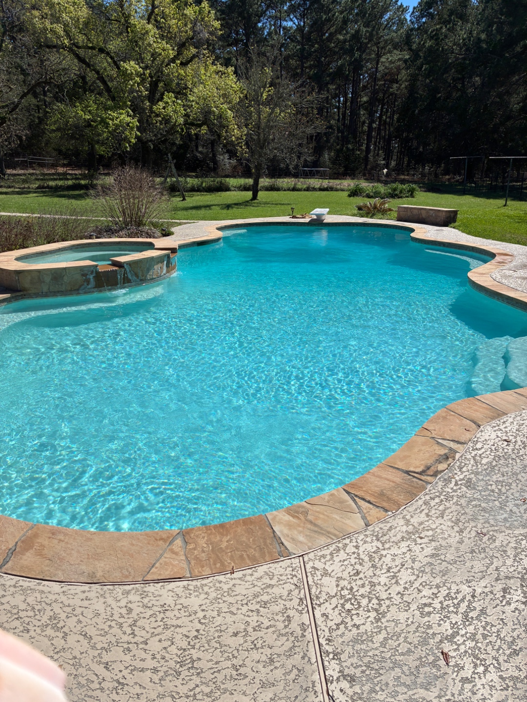 Freeform flagstone pool with spa serviced by Blue Line Pool & Spa in the Brazos Valley