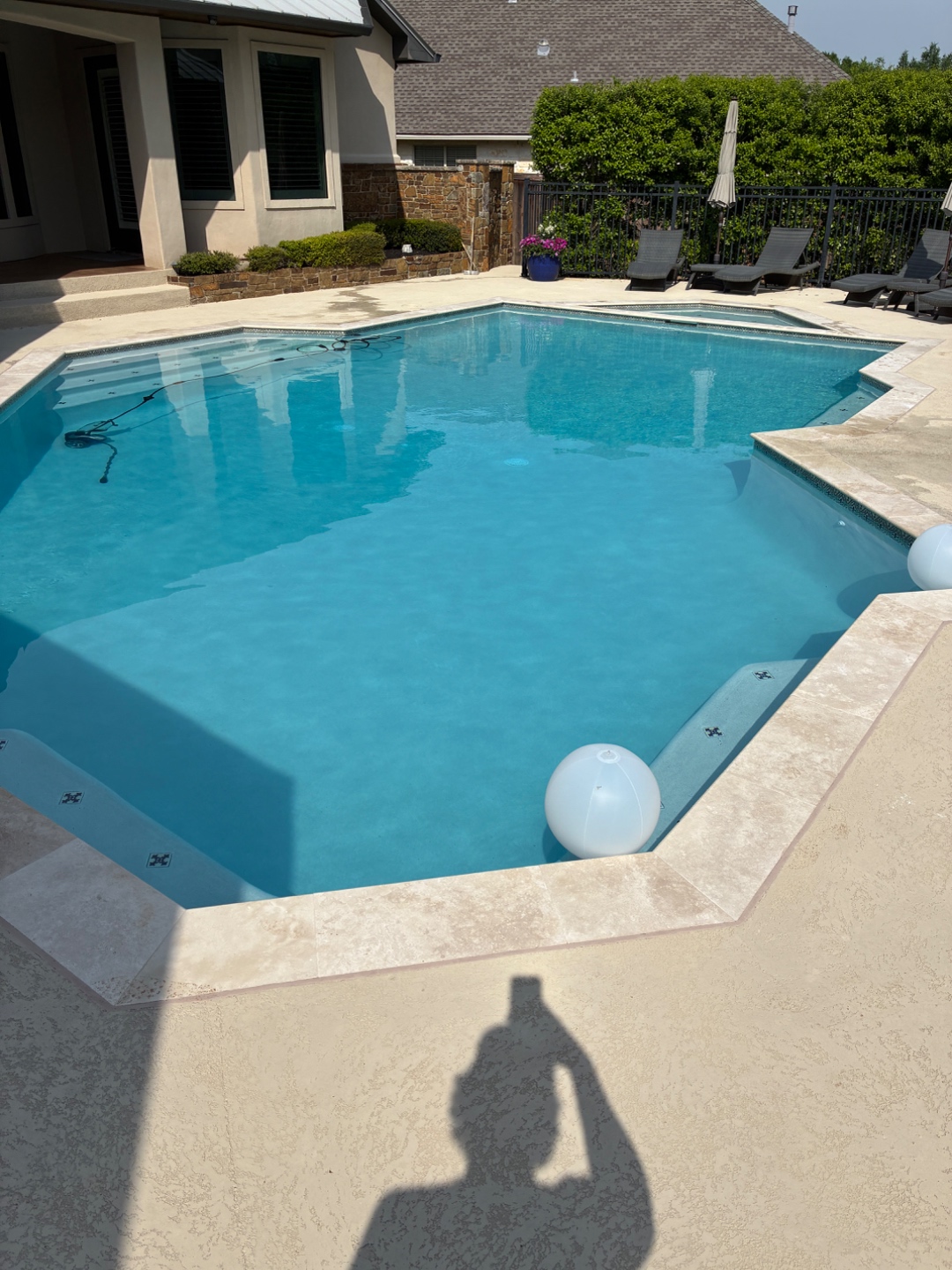 Clean rectangular pool with travertine coping maintained by Blue Line Pool & Spa in College Station